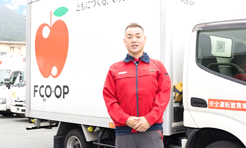 トラックの前に立つY.Y.さん