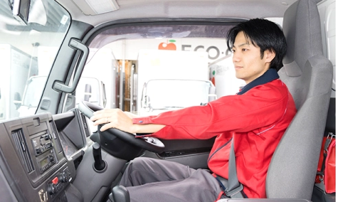 トラックの運転席に座り、これから出発するスタッフ
