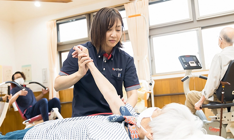 ご利用者さまのリハビリをするI.J.さん